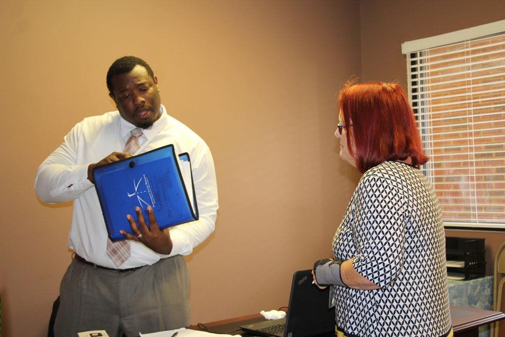 Highland Rivers Health therapist Ricardo Bermudez (left) talks with community support staffer Carol Casey during the Thursday opening celebration of their Home Again program office at 1838 Redmond Circle.